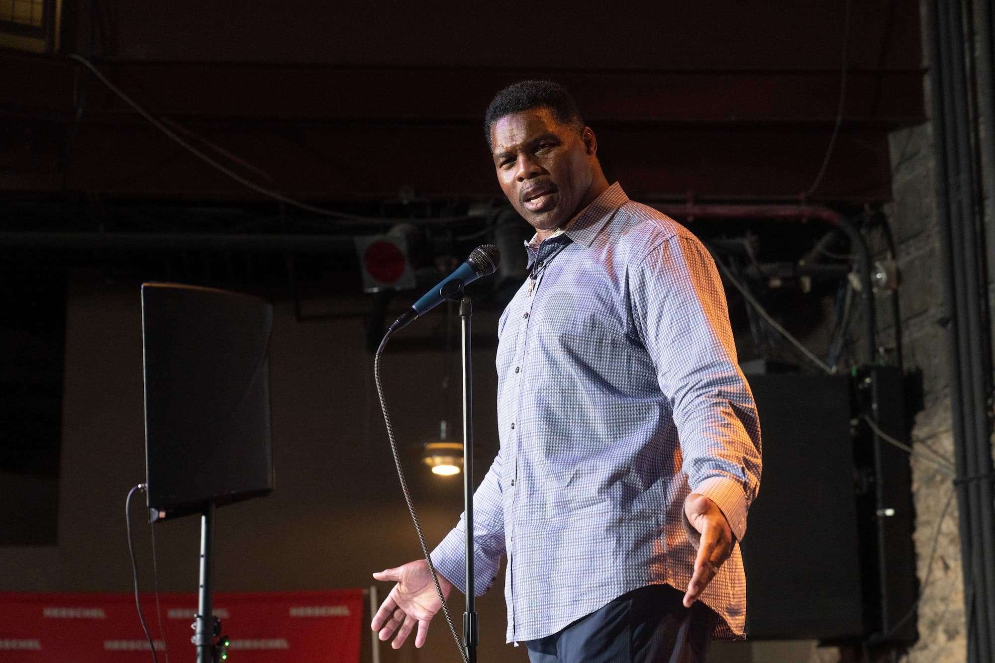 Herschel Walker speaks on stage, profile view, making face and holding hands out - 5-23-22 (1)